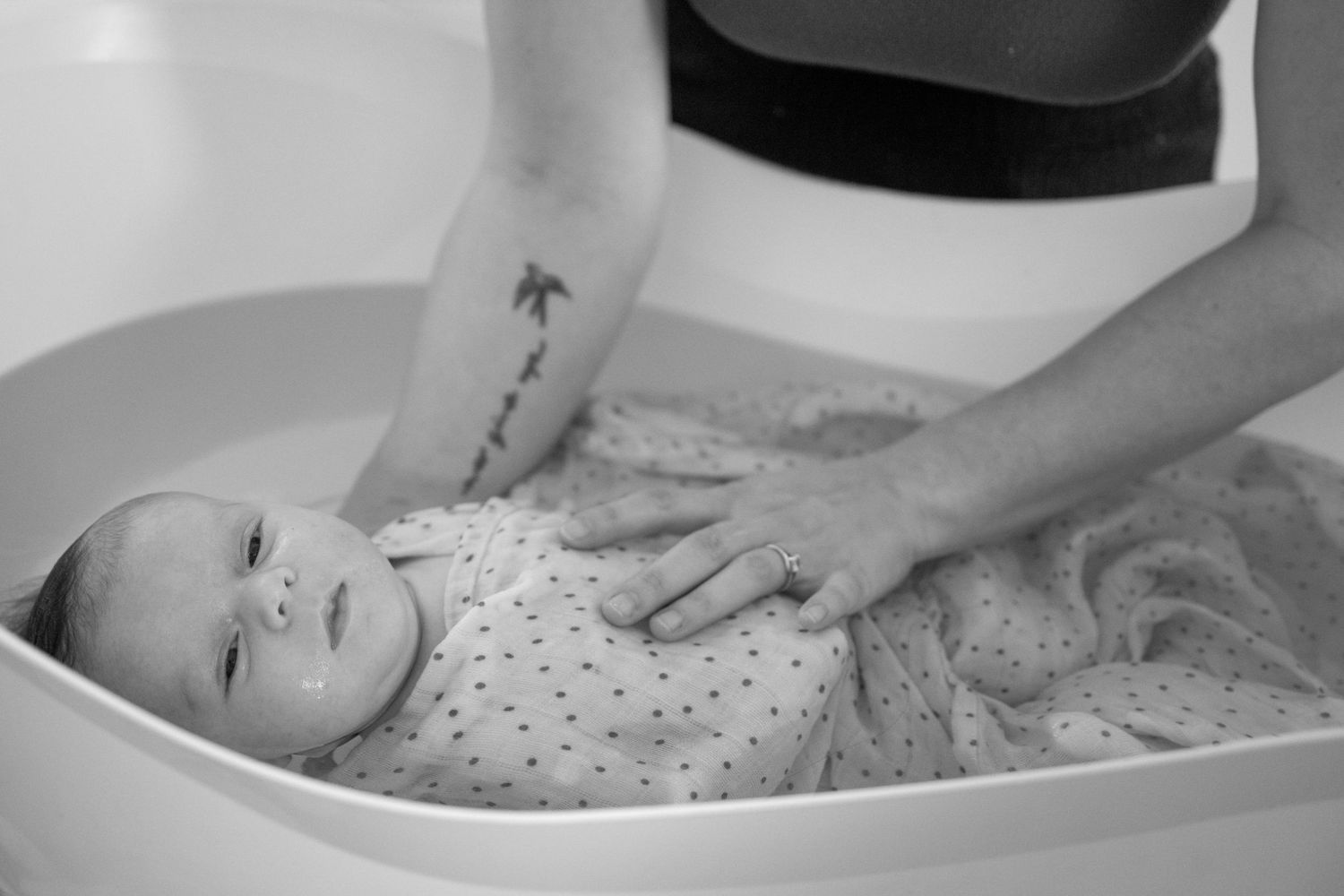 Bébé lors d'un bain enveloppé à Lentilly . Moment apaisant.
