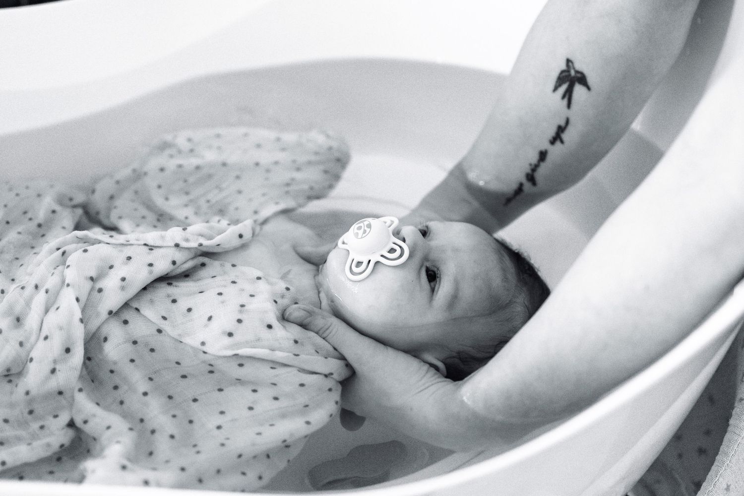 Bébé lors d'un bain enveloppé à Lentilly . Moment apaisant.