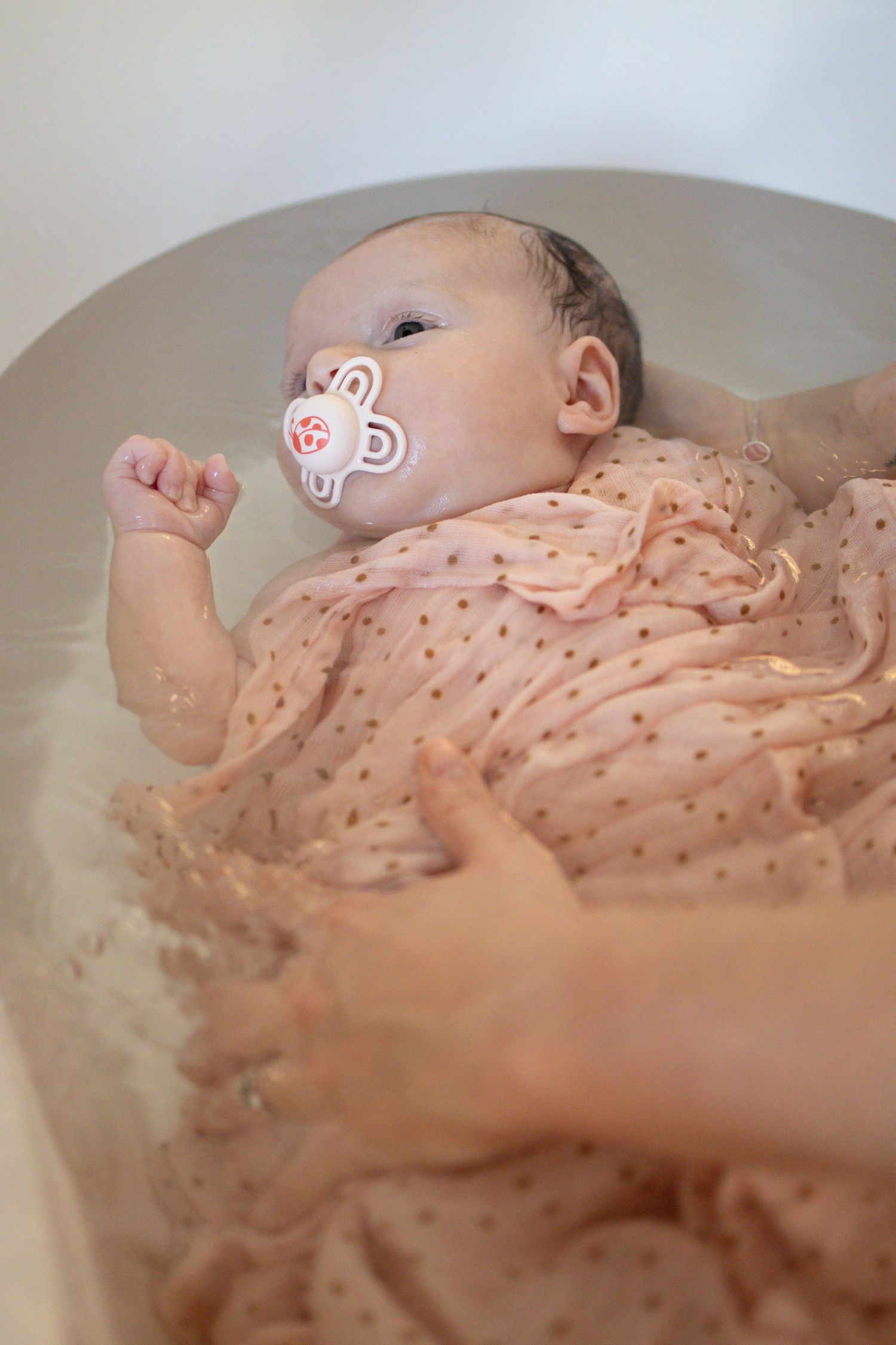Bébé lors d'un bain enveloppé à Lentilly . Moment apaisant.
