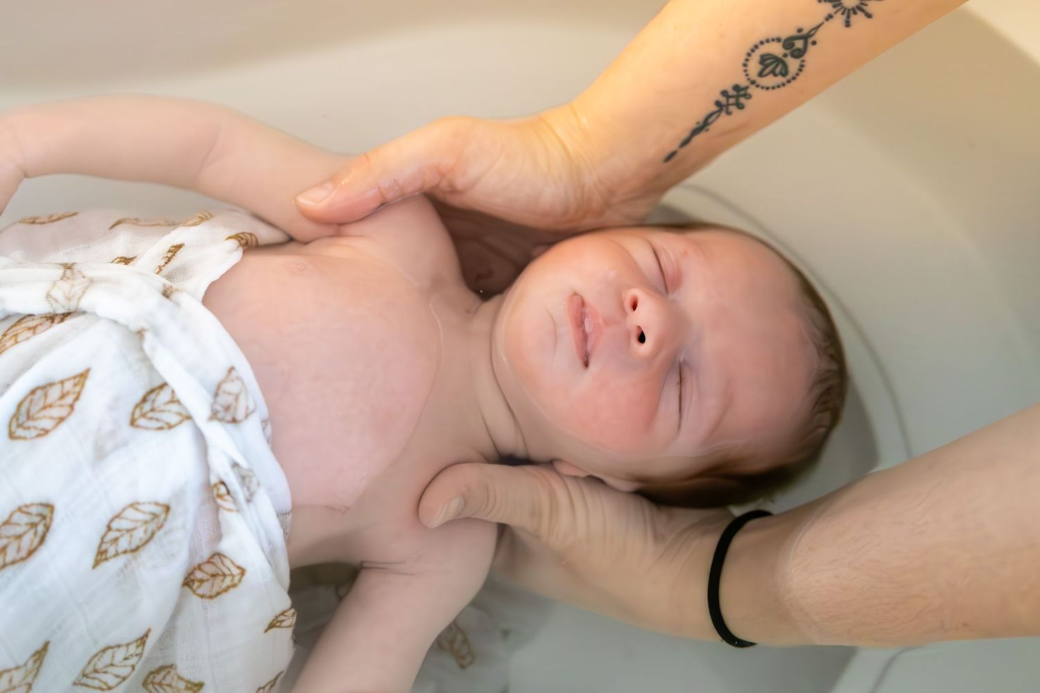 Bébé lors d'un bain enveloppé à Lentilly . Moment apaisant.