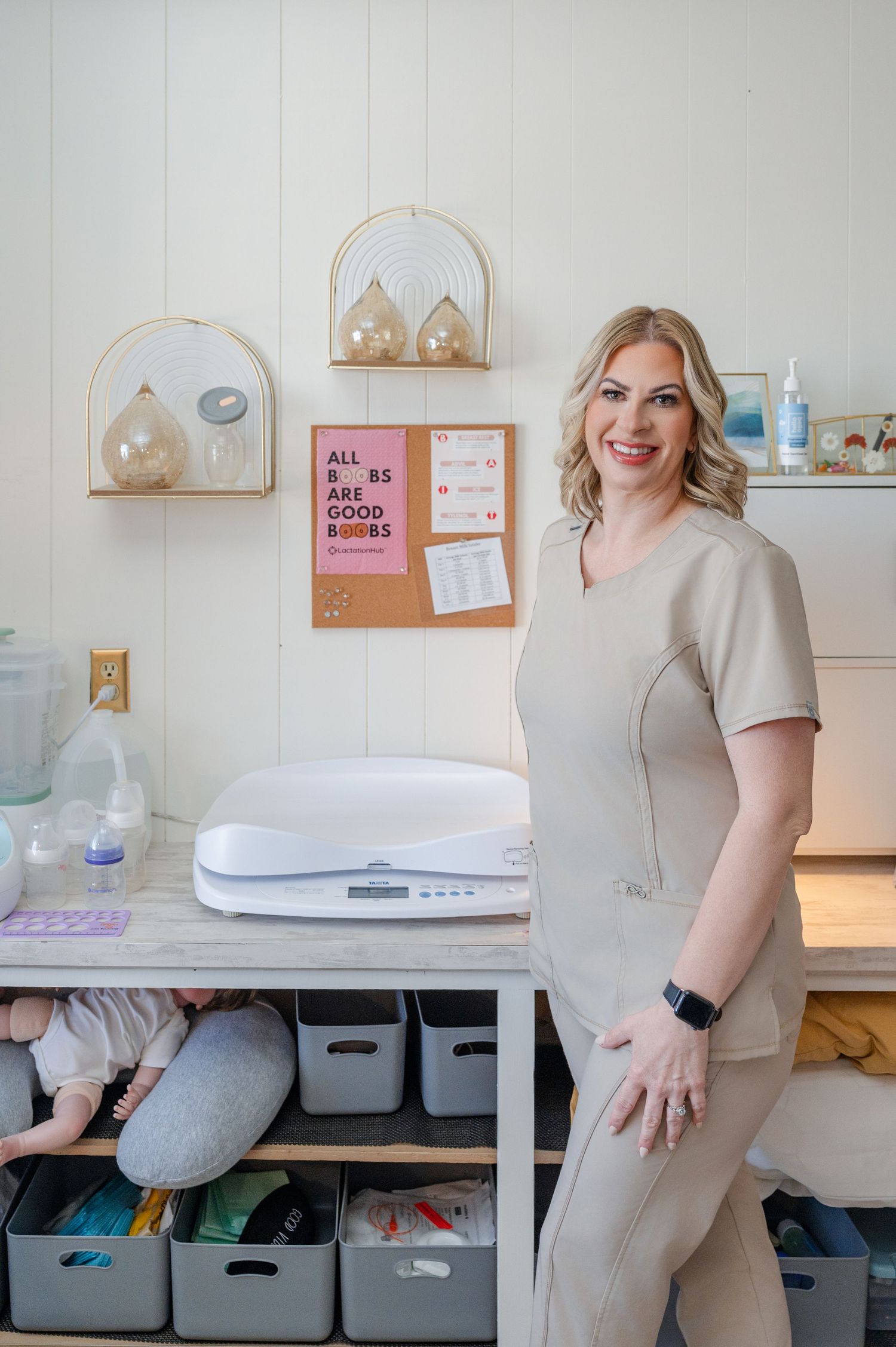 Personal Branding Photo - a lactation consultant in beige scrubs with lots of baby accessories