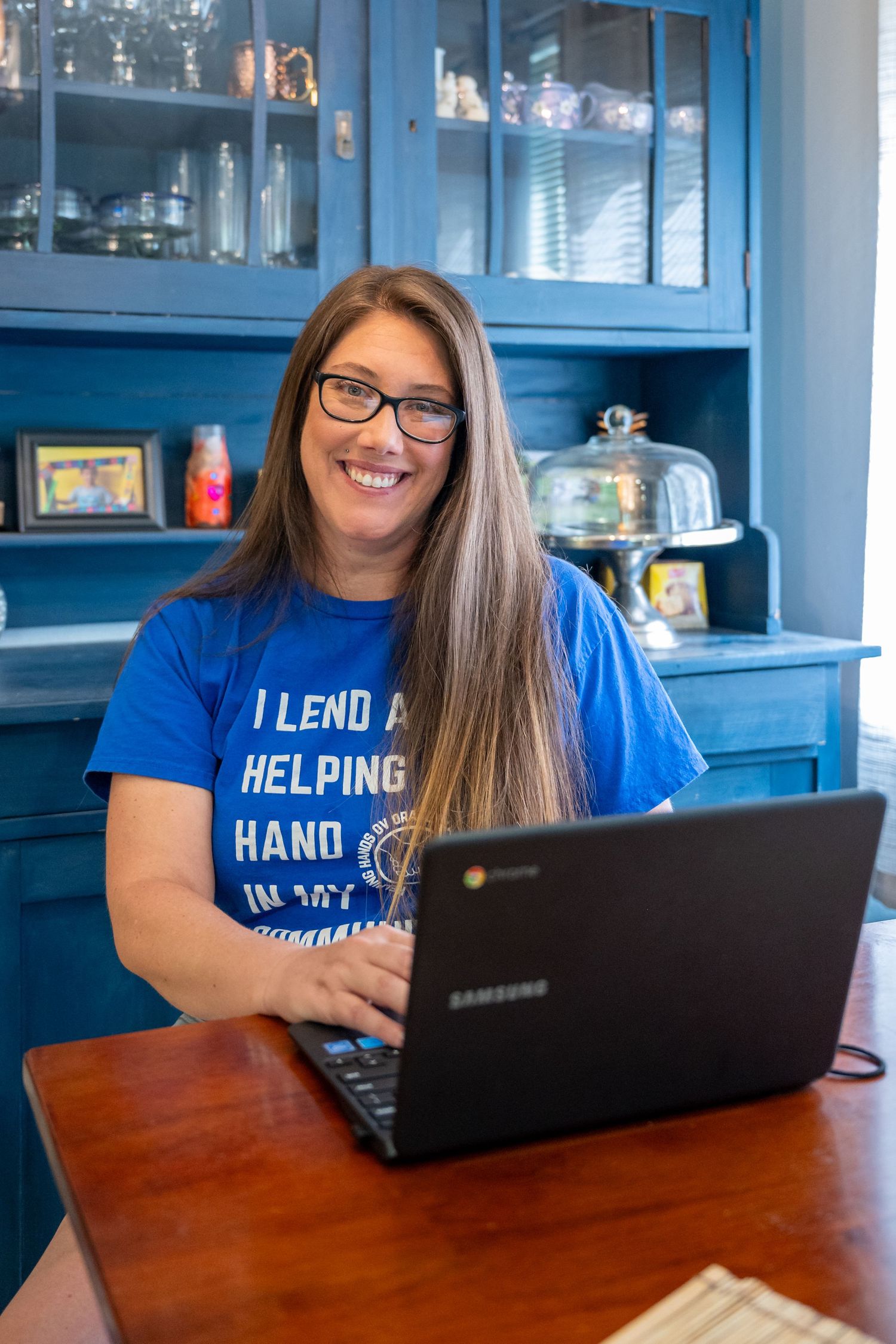 Personal Branding Photo of the leader of Helping Hands of Orangevale - Fair Oaks, taken at her home.  She's posed in front of a laptop.