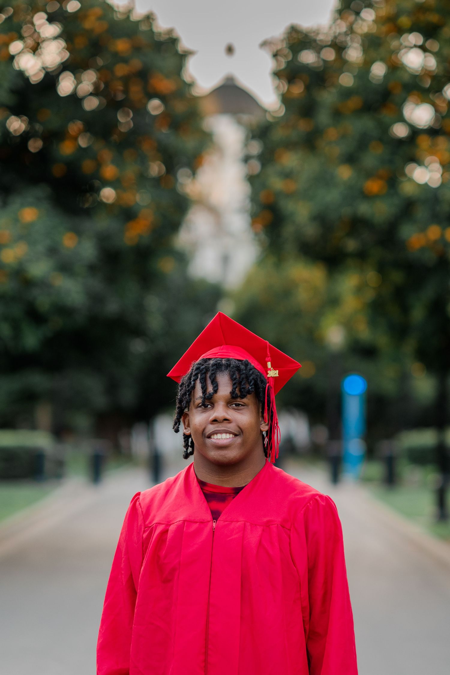 A Senior Boy in a red cap and gown taken at the California State Capitol in Sacramento, California