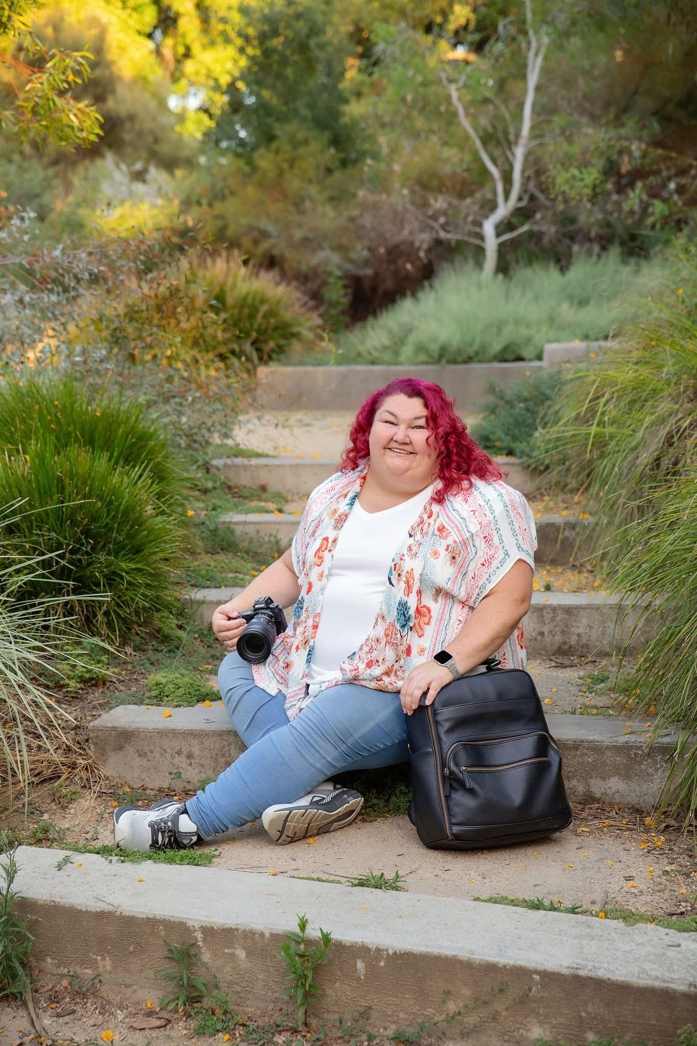 Cathy Kurtz, the photographer is shown sitting on some steps with her camera and camera bag.