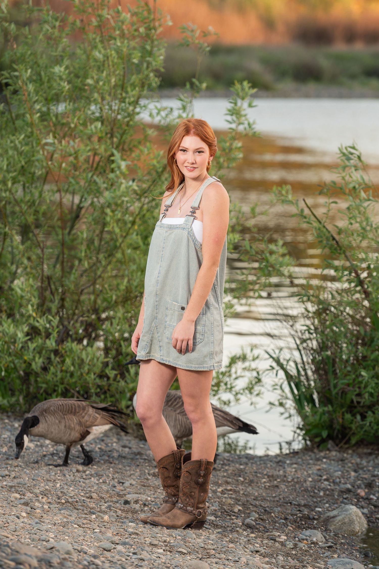 High School Senior girl in front of some tall plants by the American River at Sailor Bar County Park