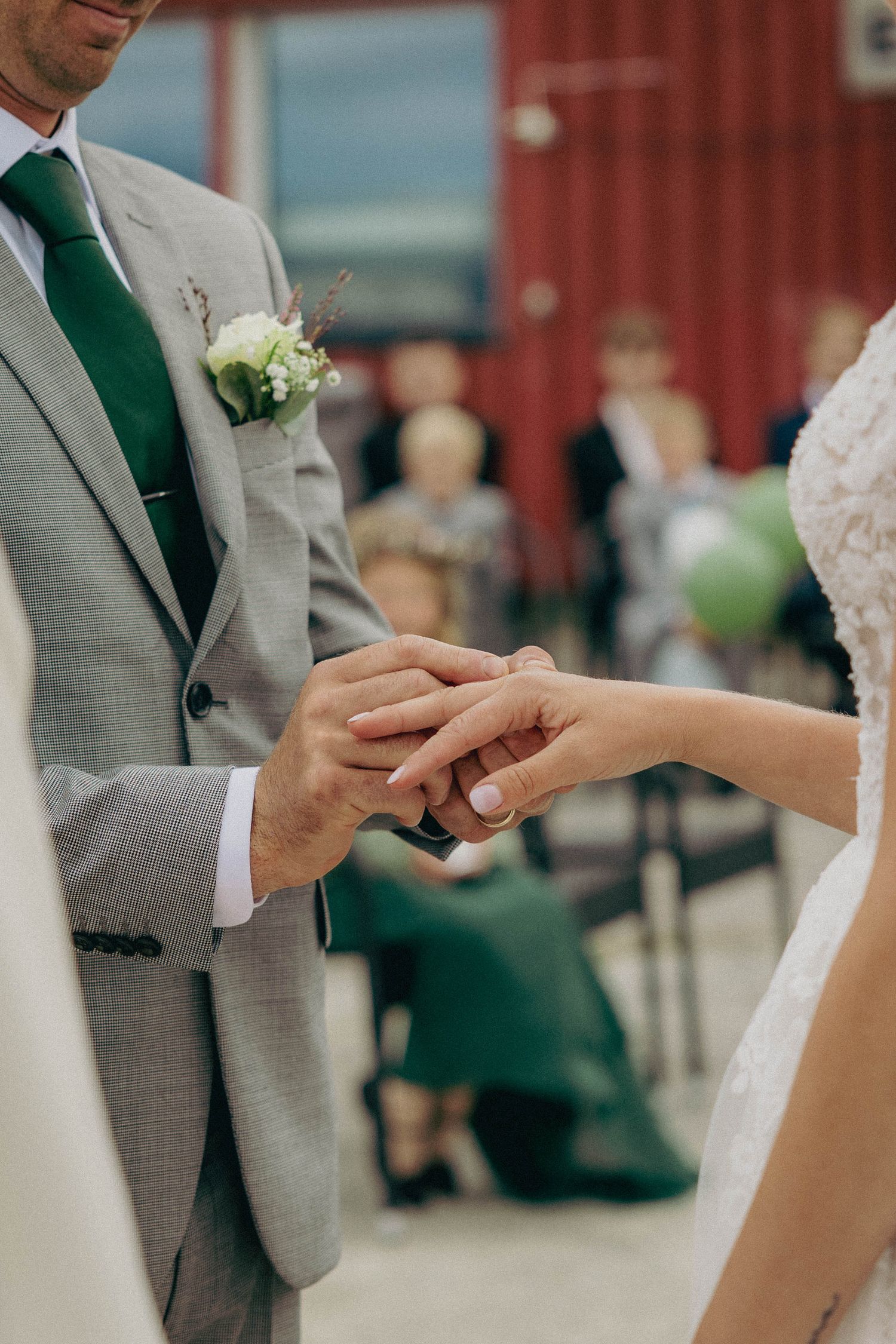 Bryllupsfotograf som har fotografert øyeblikket der brudgommen setter på ringen på brudens finger under vielsen.