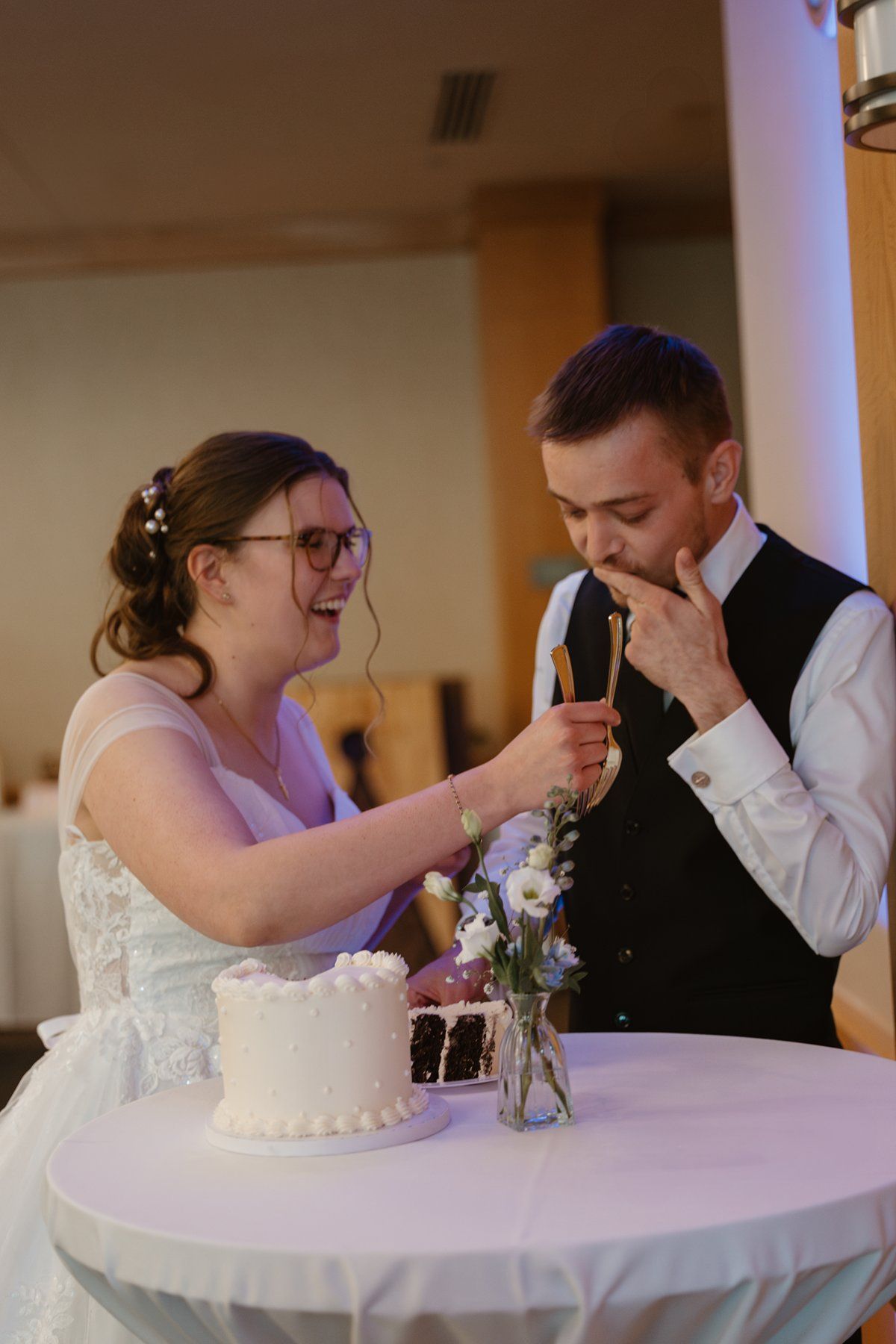 A wedding couple shares a heartfelt moment while cutting their cake at their reception.