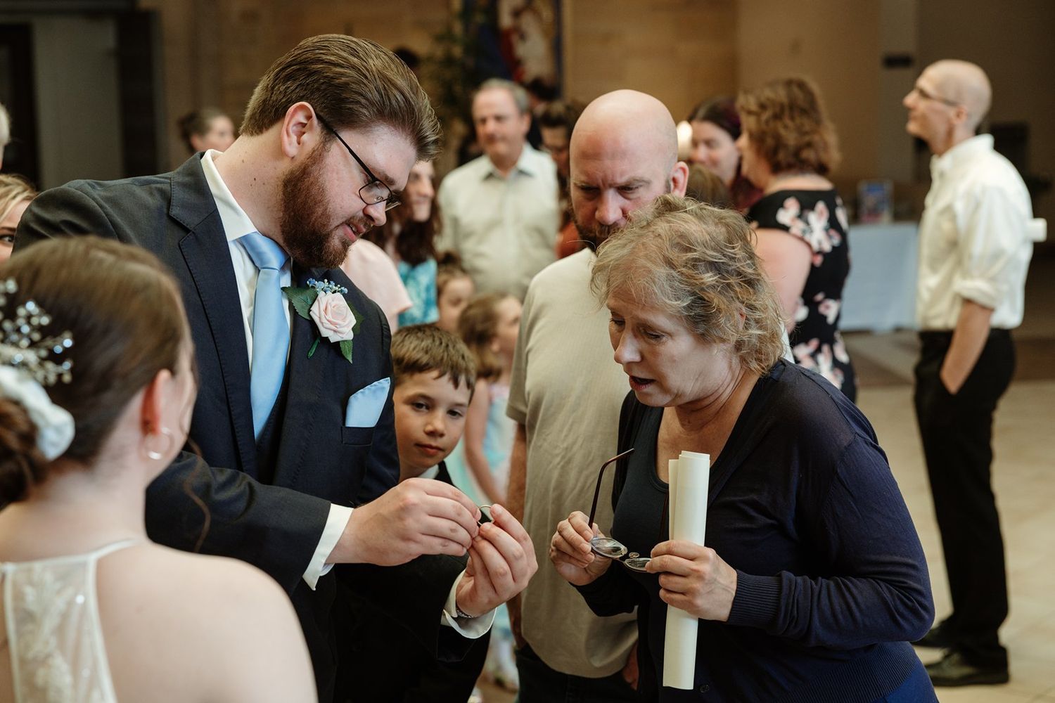 Wedding guests gather in a church reception area after the ceremony, sharing moments of celebration.