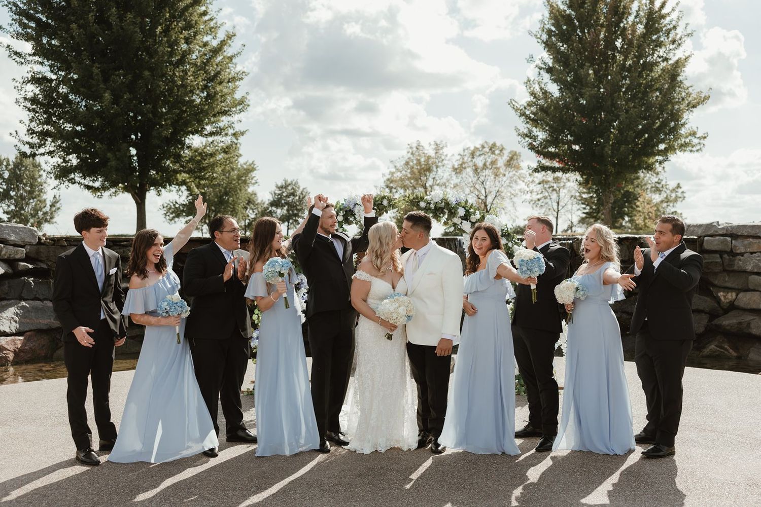 wedding party taking photos at the Wexford at Emerald Greens in front of the waterfall ceremony location