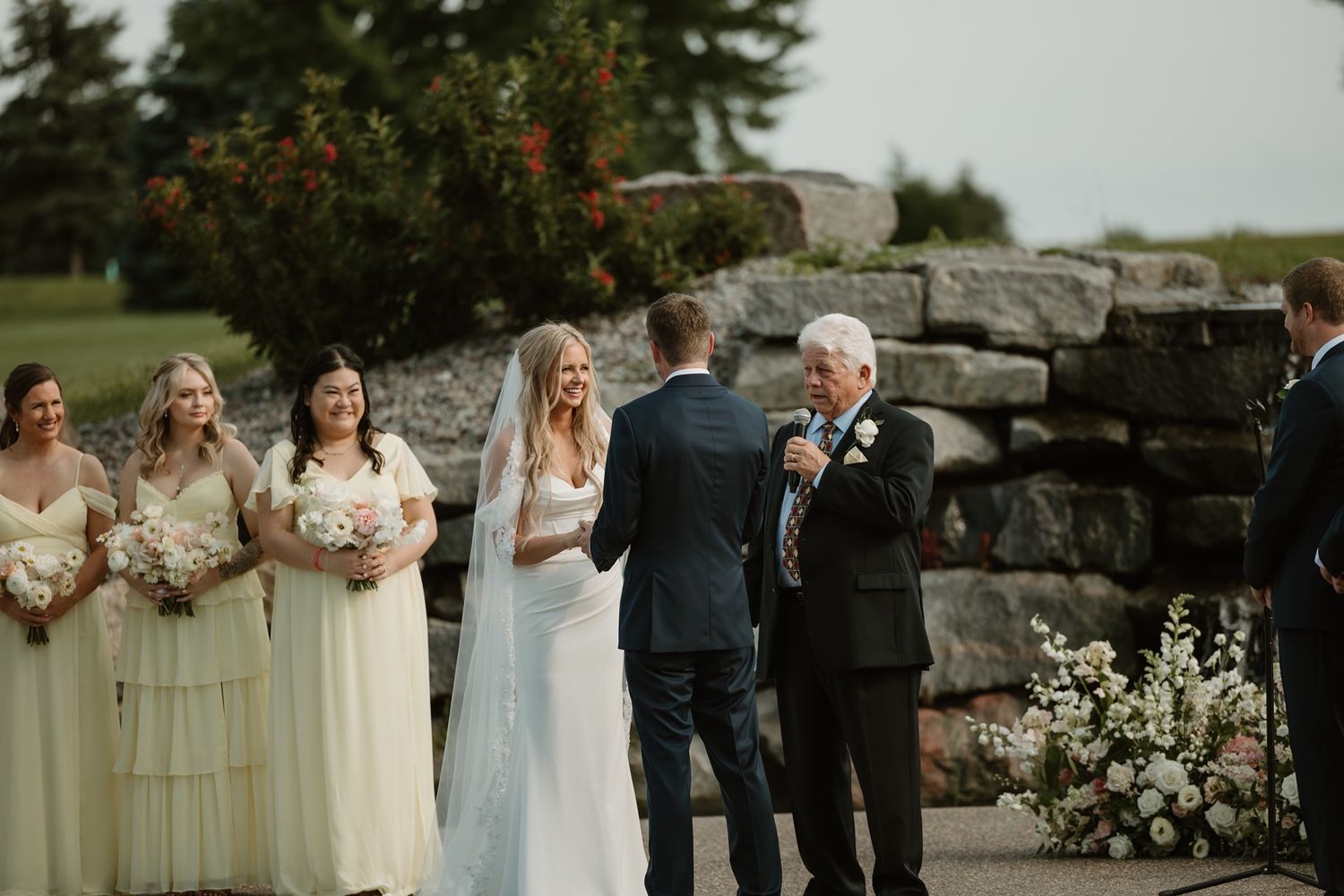 Minneapolis wedding photographer capturing candid ceremony moment of bride smiling at the groom