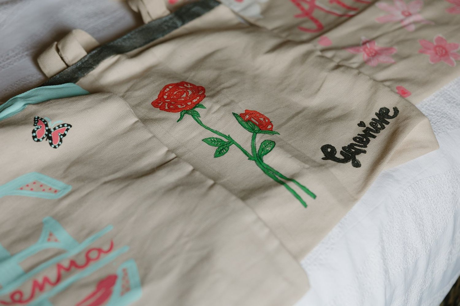 A series of fabric pieces laid out showing embroidered designs with red, green, and blue thread patterns.