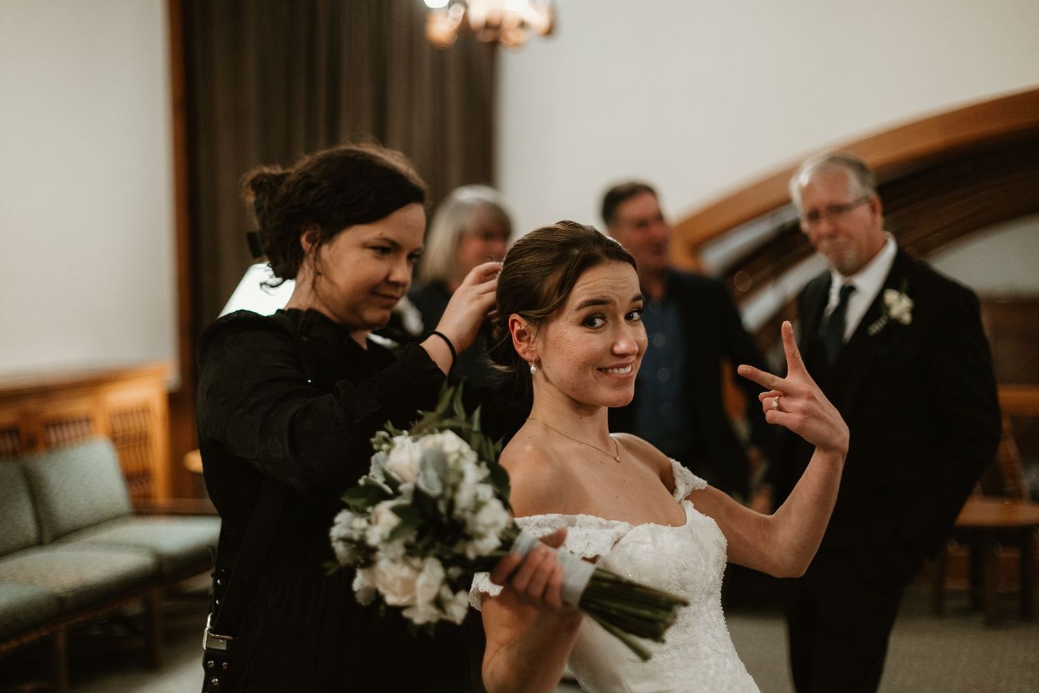 A bride holds a white bouquet during her wedding ceremony in a traditional church setting.