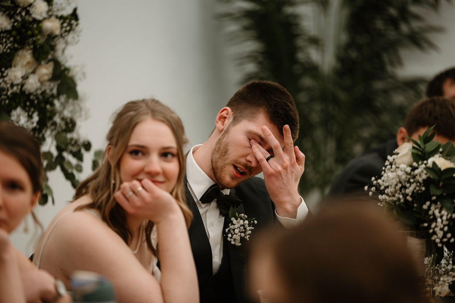 Wedding couple shares intimate moments in a romantic outdoor setting with floral decorations and natural lighting.