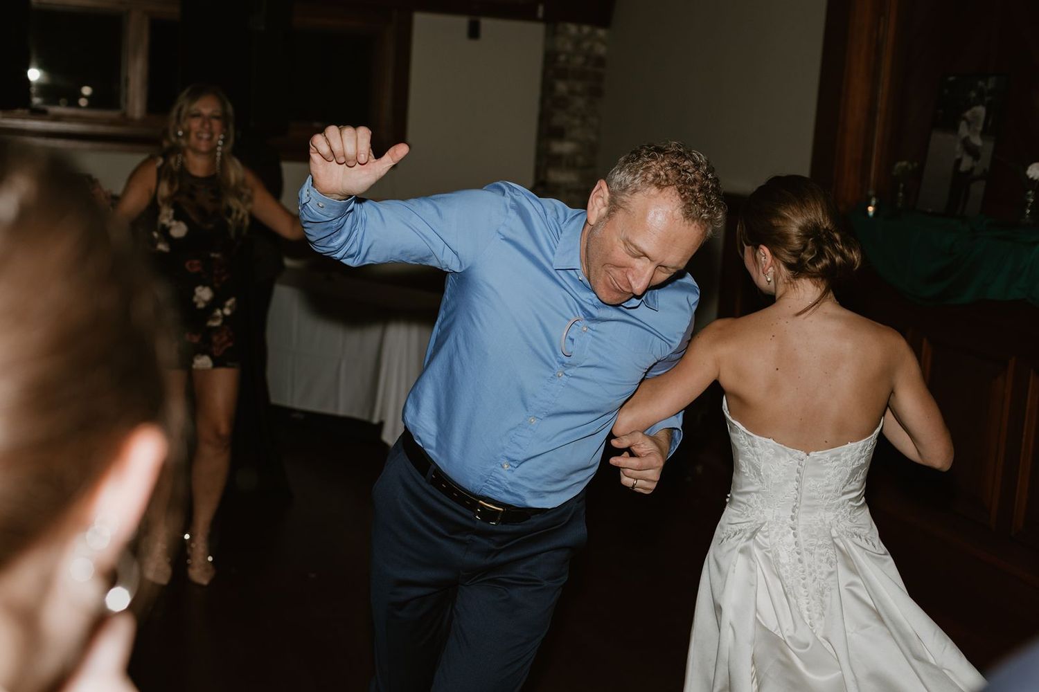 Guests dancing enthusiastically at a wedding reception in an indoor venue.