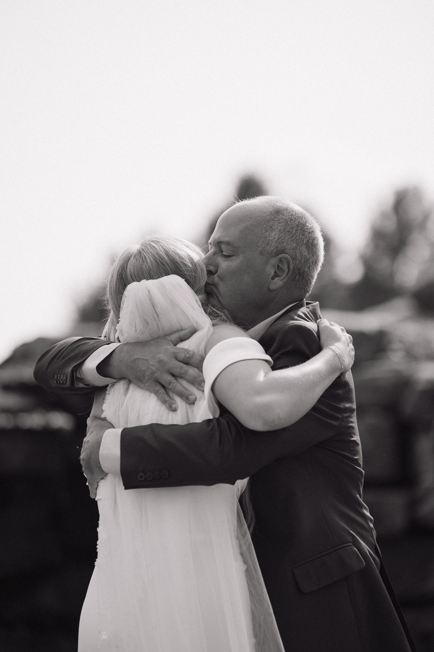 Black and white series of emotional embraces between two people at an outdoor event.