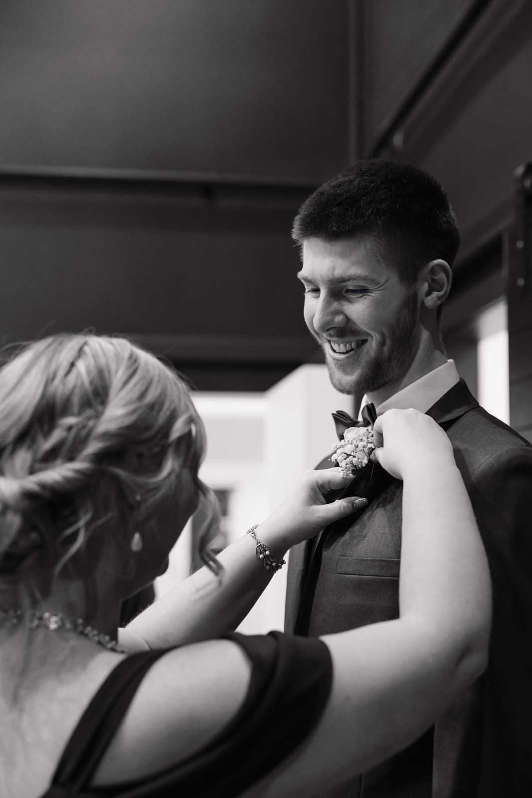 Black and white photos showing hands adjusting a bowtie during formal preparation.
