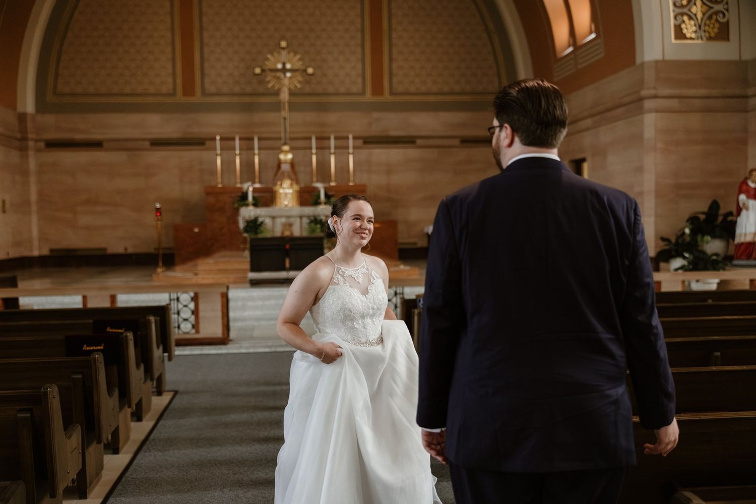 A joyful moment captured during a traditional church wedding ceremony with wooden pews and candlelit altar.