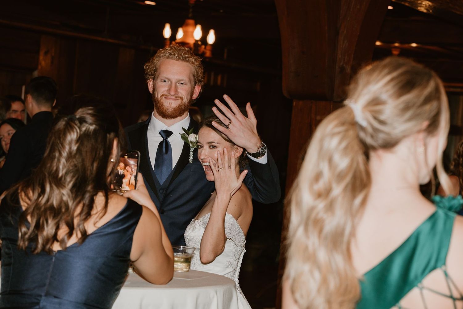 Wedding reception guests dancing and celebrating in a rustic venue.