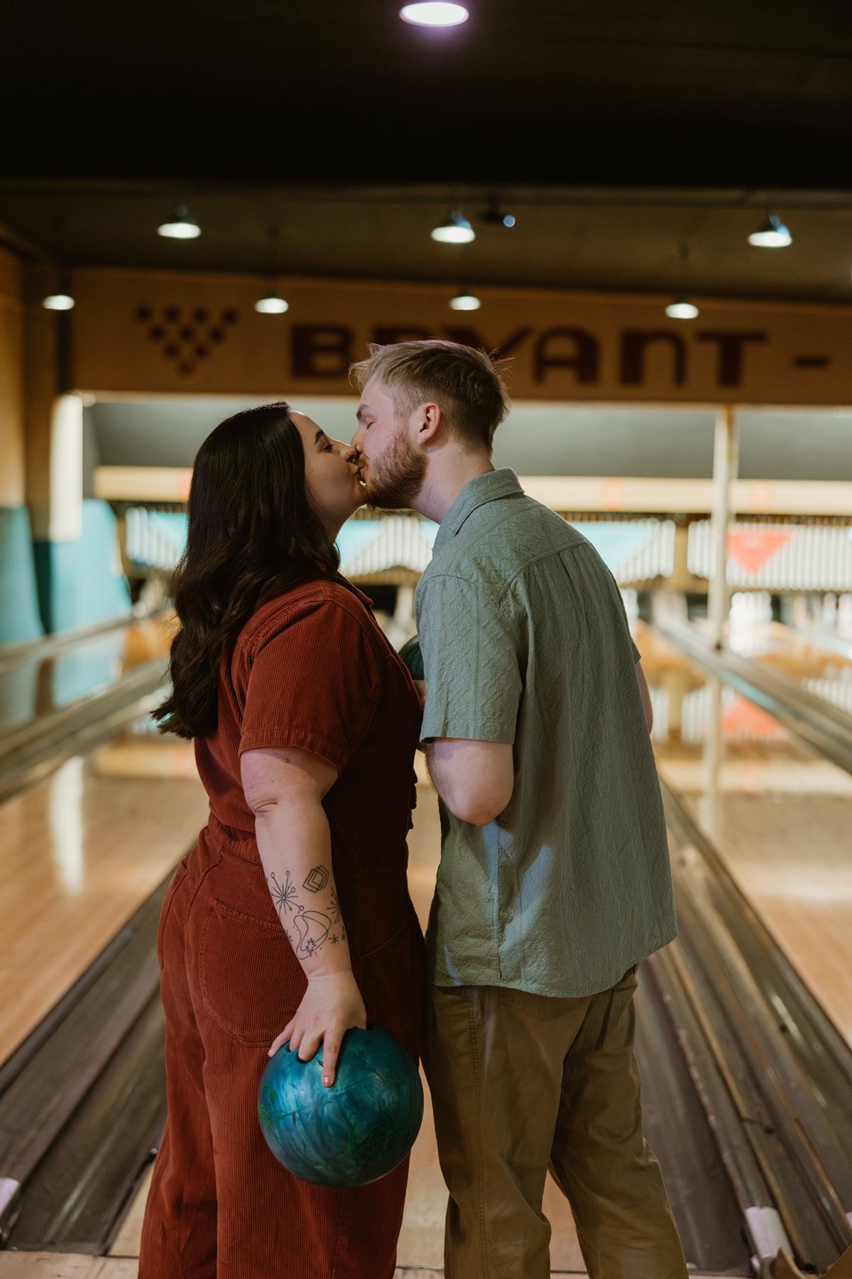 A romantic moment between a couple at a retro bowling alley with vintage lighting.
