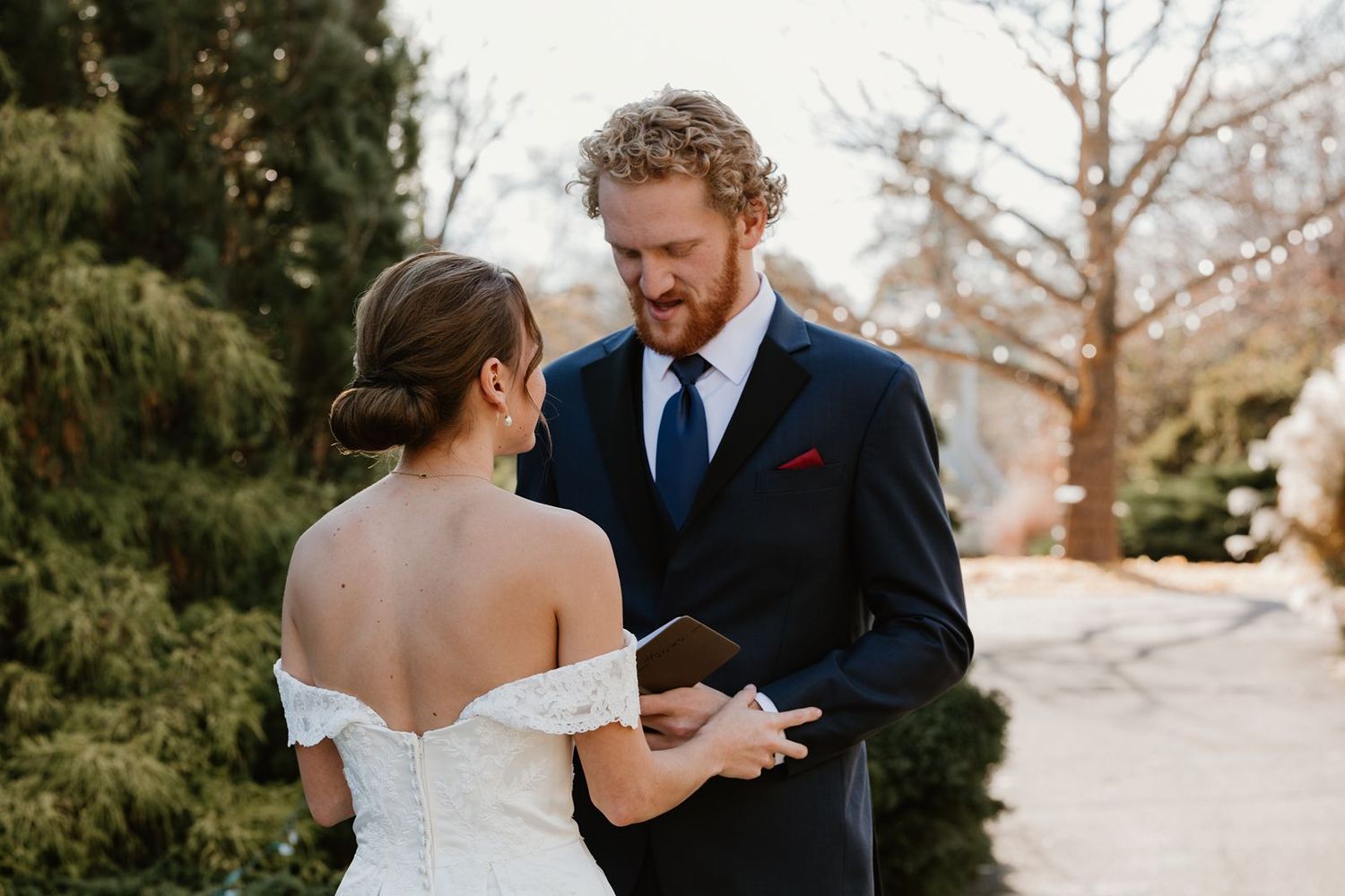 Couple exchanging vows at the MN Landscape Arboretum during outdoor autumn wedding ceremony.