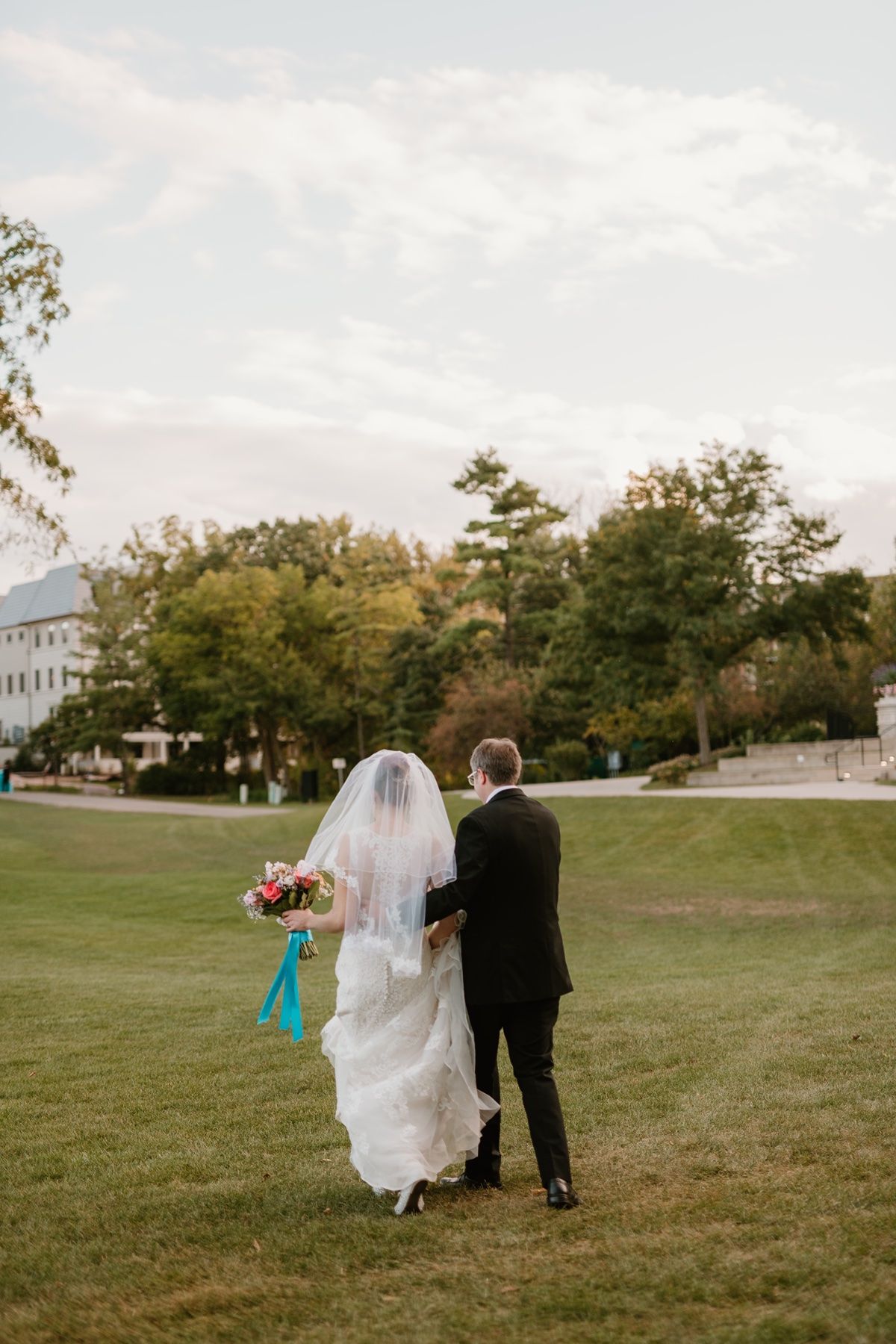 wedding photographer in Minneapolis and beyond documenting a groom helping his bride with her dress train.