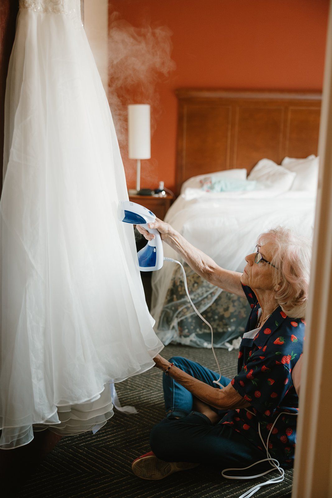 A series of photos showing someone lying on the floor underneath a flowing white wedding dress with blue accents.