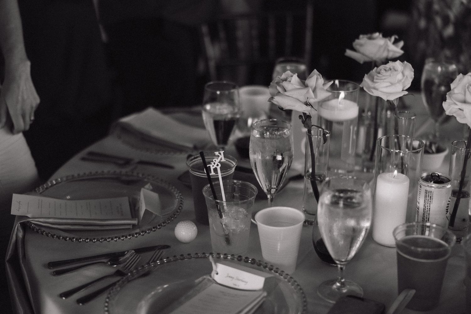 Black and white table setting with champagne glasses, flowers and candles at an elegant dinner party.