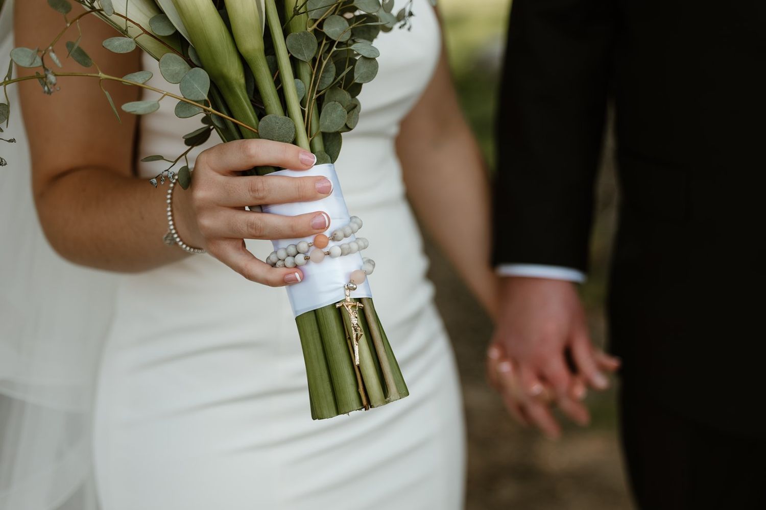 Close-up detail of a white wedding dress with elegant lace and beading patterns.