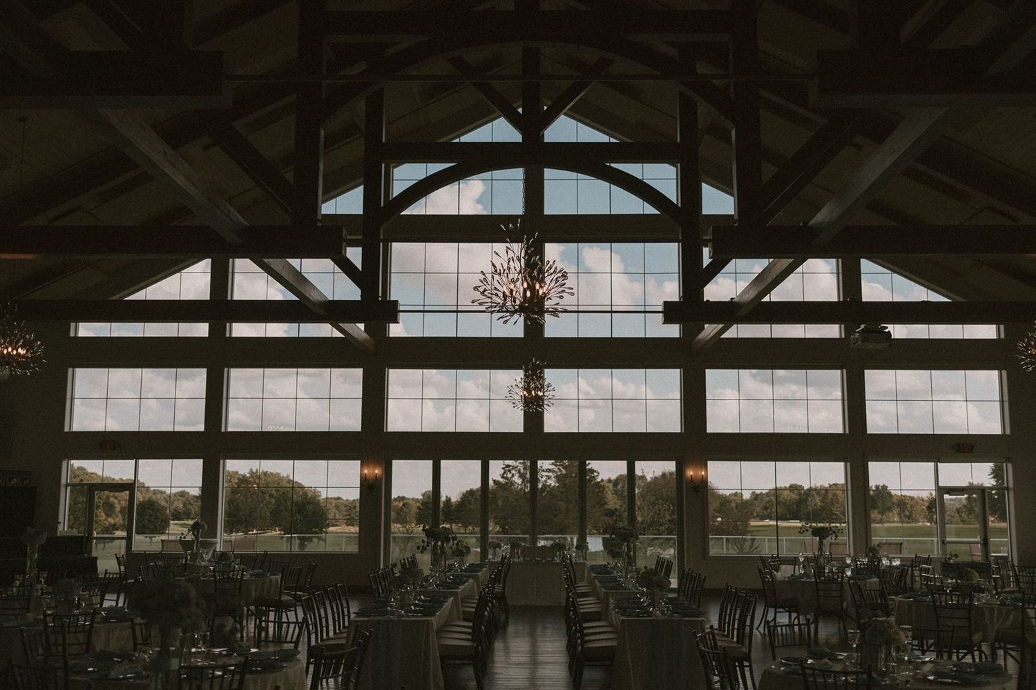 A modern wedding venue interior with vaulted ceilings and large windows overlooking scenic views.