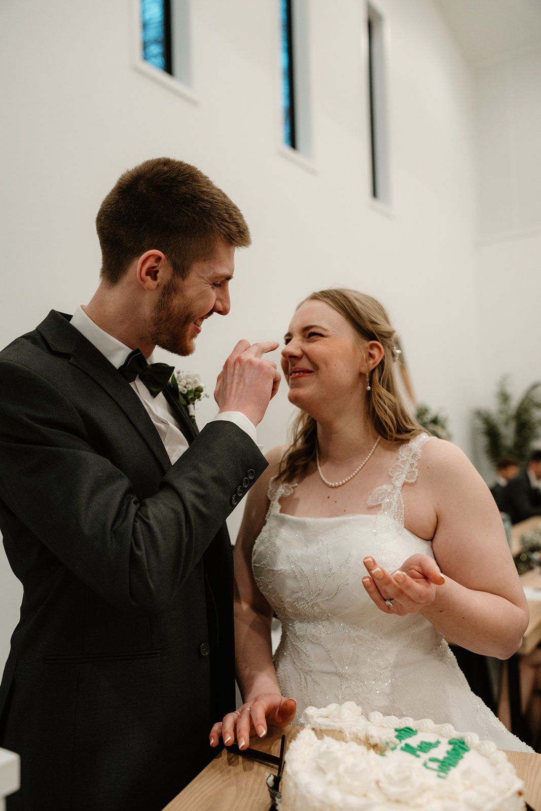 A romantic moment between newlyweds sharing laughter and joy during their first dance at a wedding reception.