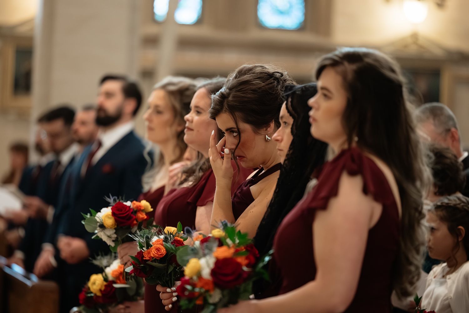Bridesmaid getting emotional during a catholic wedding ceremony