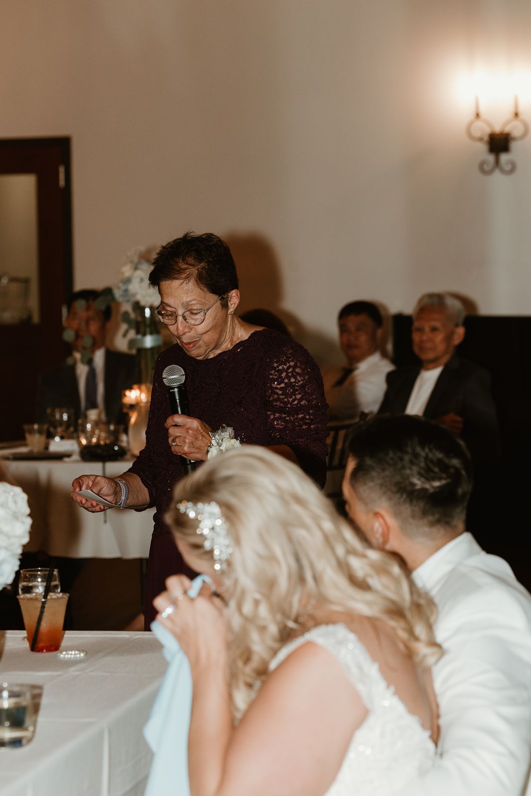 Wedding reception scene showing guests giving toasts during dinner.