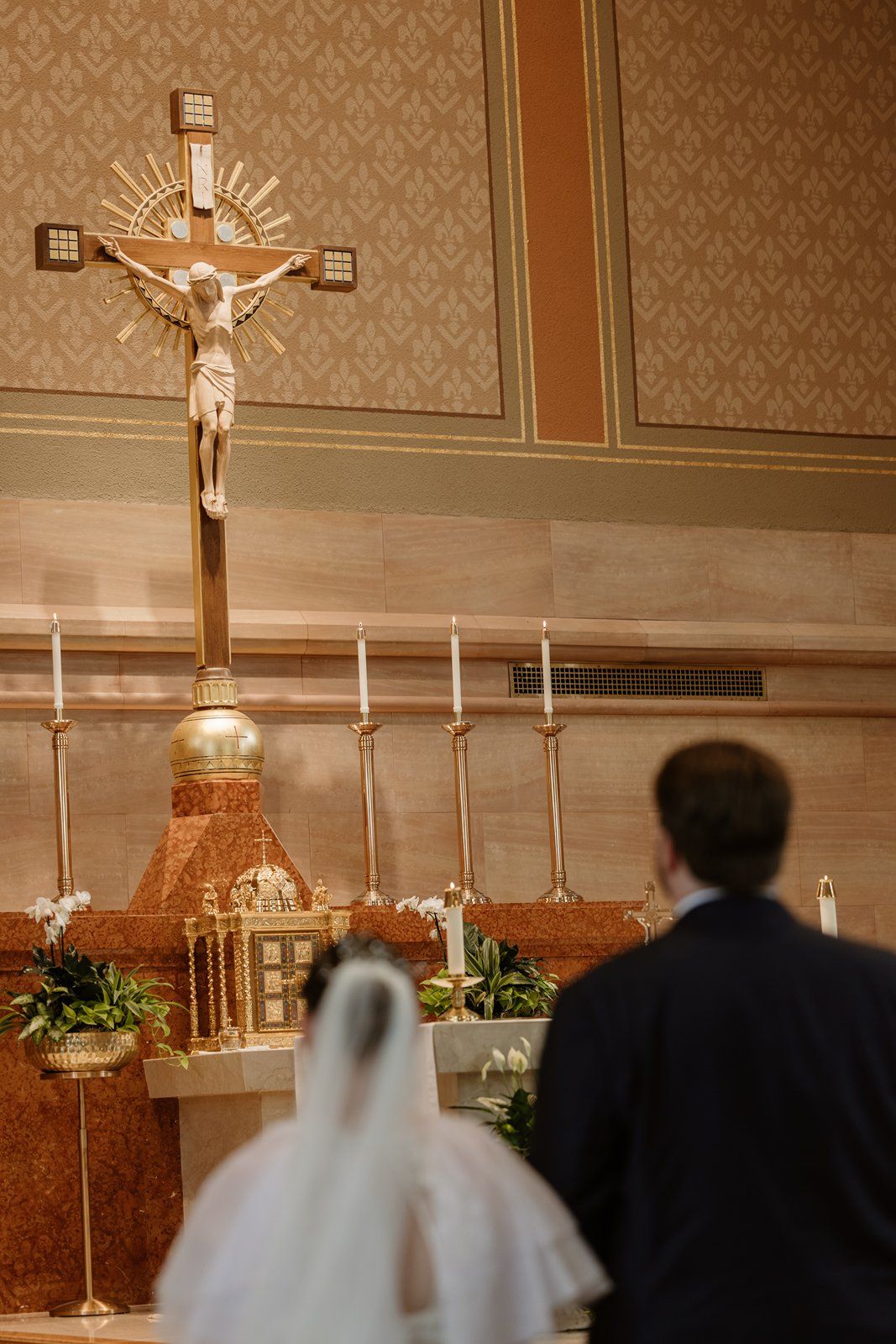 A church altar with crucifix and candles during a wedding ceremony.
