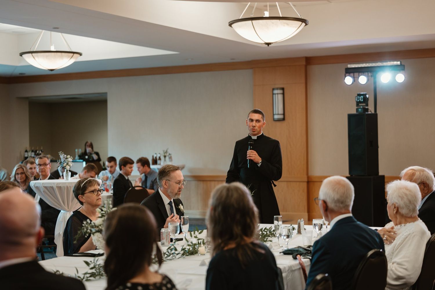 People gathered in a conference room for a formal event under overhead lighting.