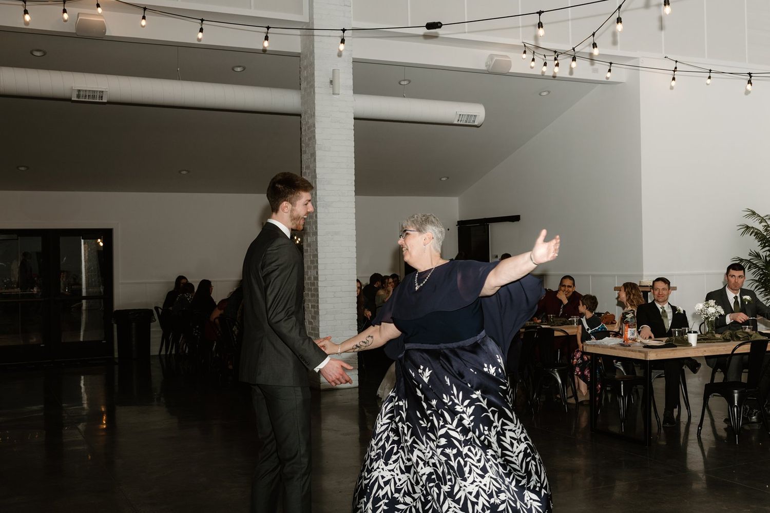 A sequence of photos showing people dancing and mingling at an indoor social gathering with string lights overhead.