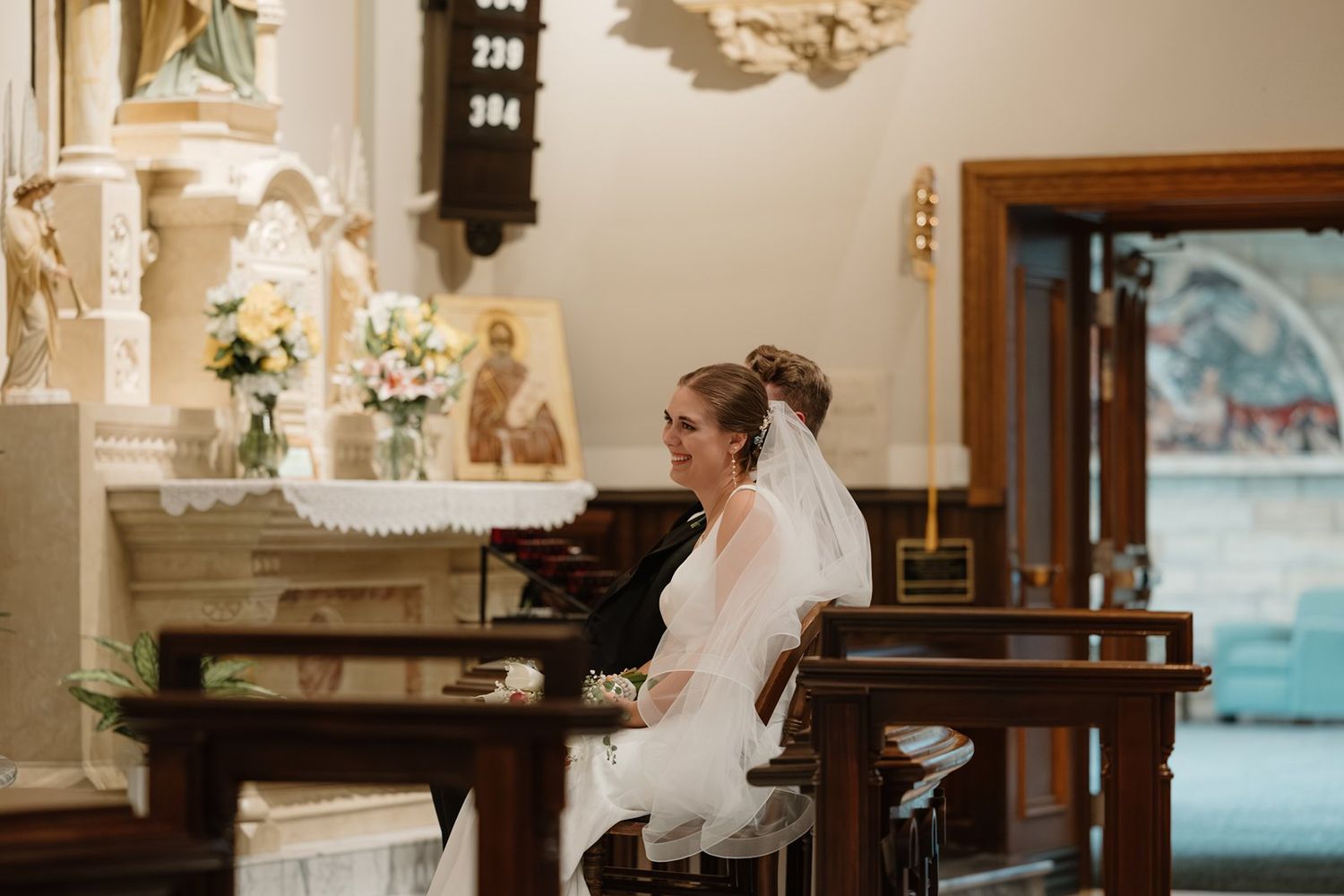 Elegant wedding decorations and floral arrangements adorn a church altar area.