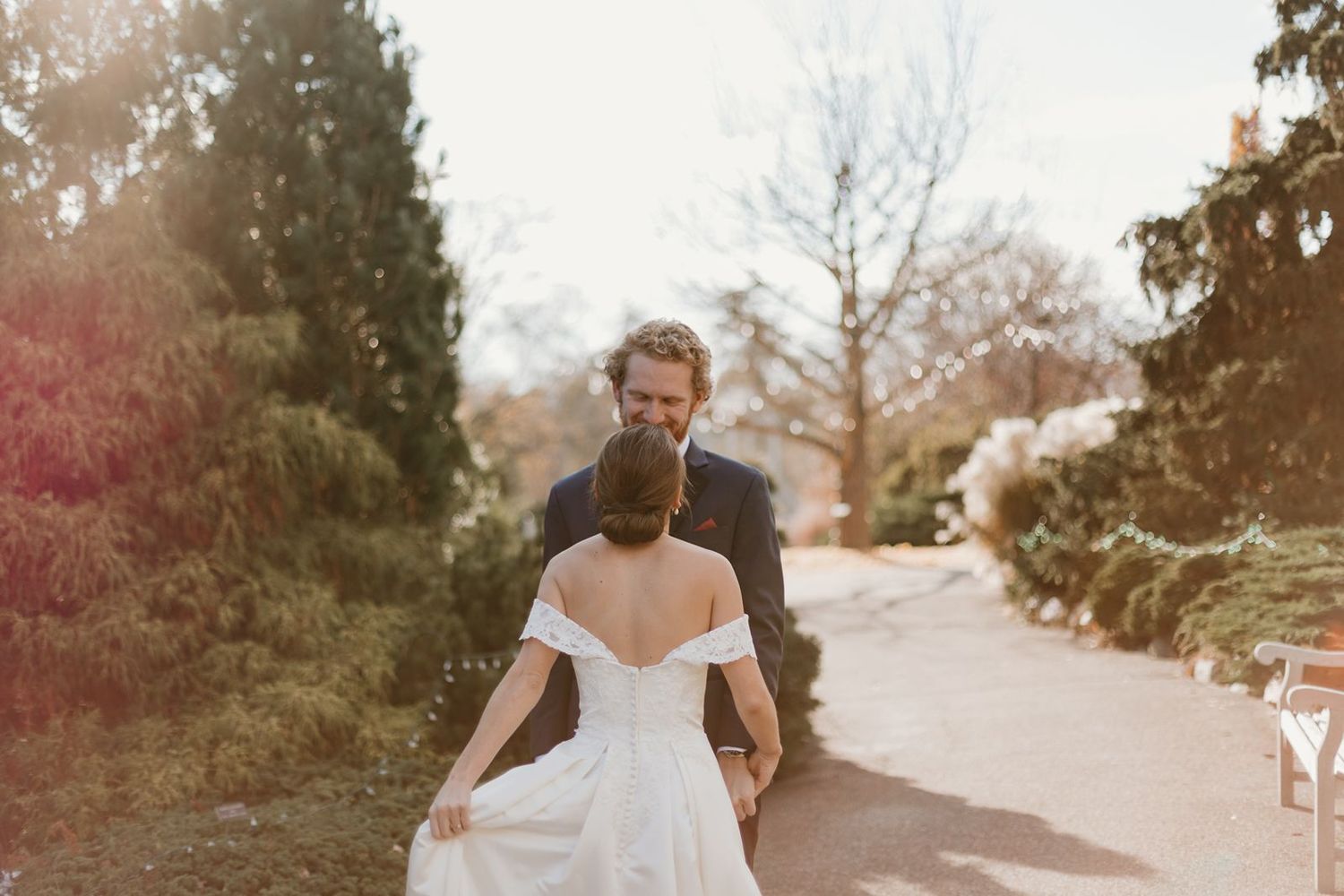 Wedding couple sharing an intimate first look moment on a garden path.