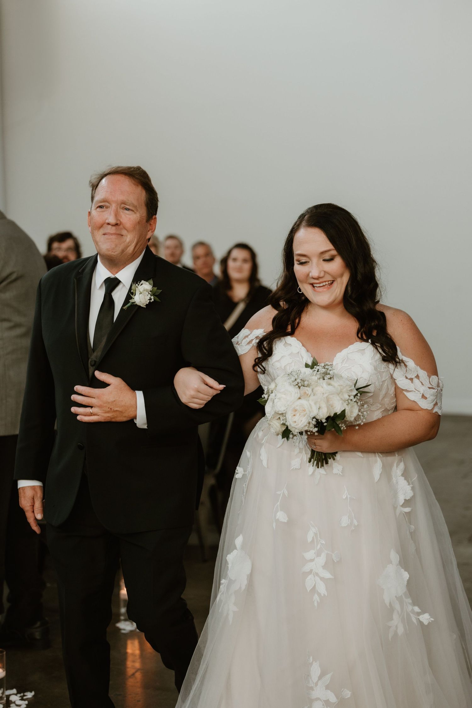 A bride and her escort walk down the aisle in a heartwarming moment during a wedding ceremony.