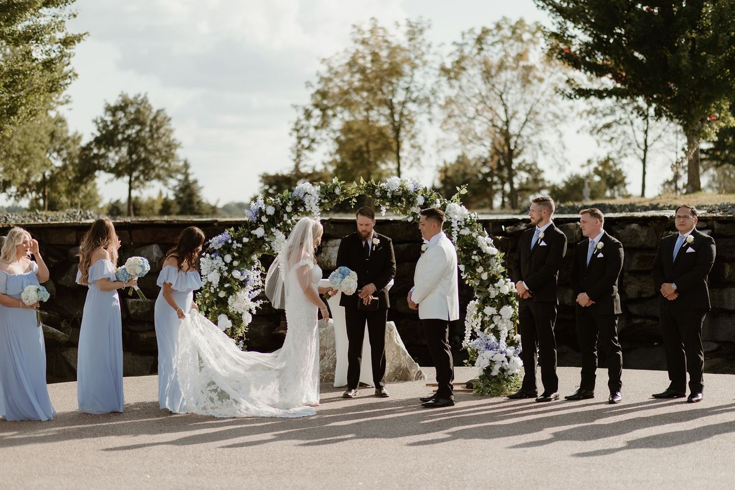 The Wexford at Emerald Greens wedding ceremony in front of a gorgeous waterfall and a magnificent floral arch.