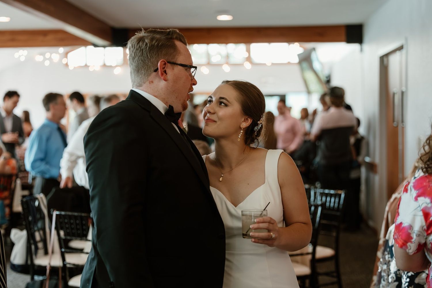 A couple shares a joyful moment together while dancing at their wedding reception in an indoor venue.