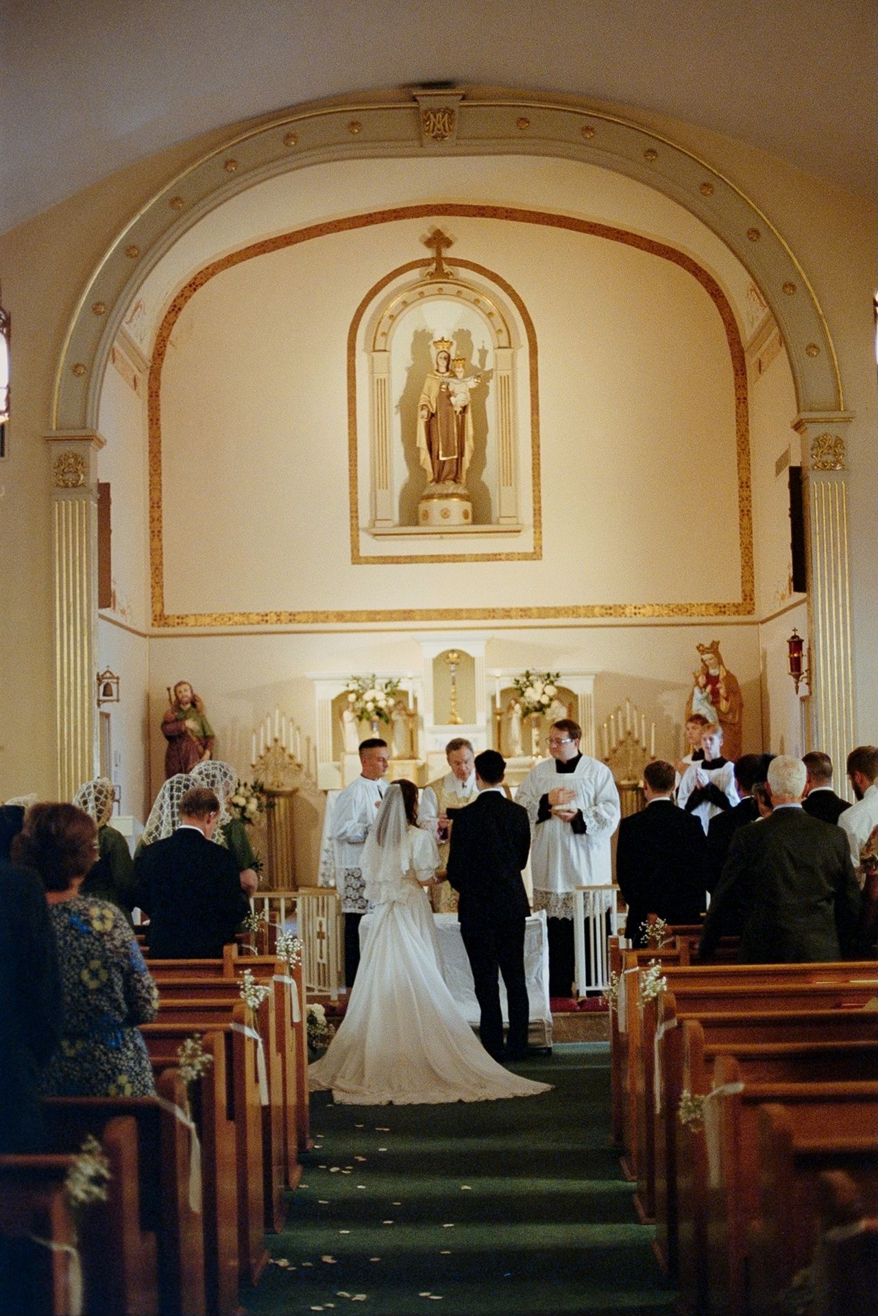 35mm film photography photos of a couple exchanging vows during a Catholic church wedding ceremony