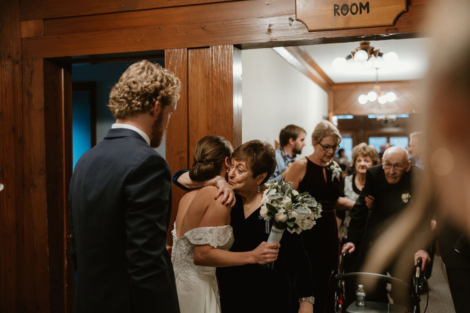 Wedding party members gather in an intimate moment during the ceremony.