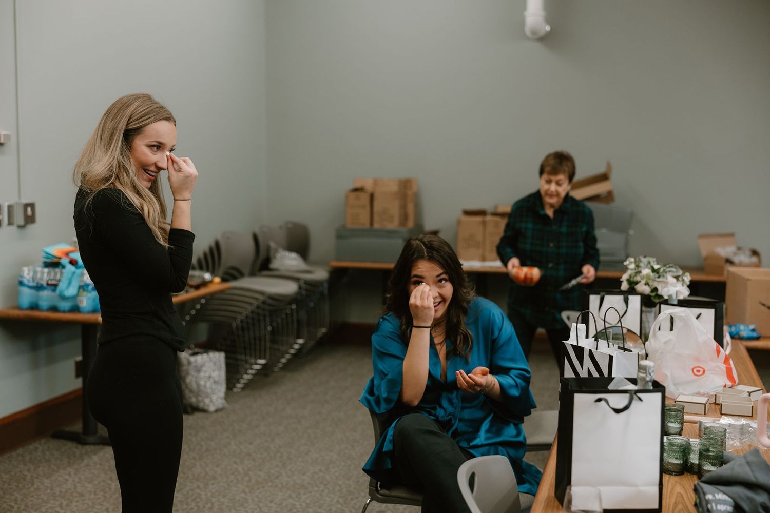 Wedding preparation scene with people getting ready in casual setting with gift bags.