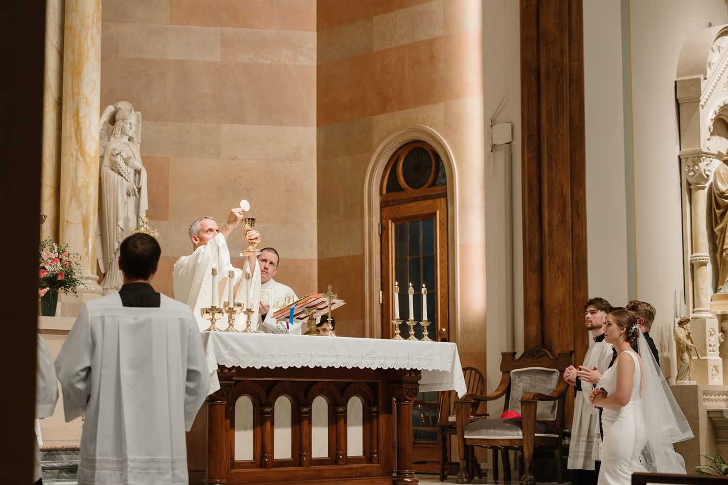 Interior view of ornate church sanctuary with stone columns and religious statues.