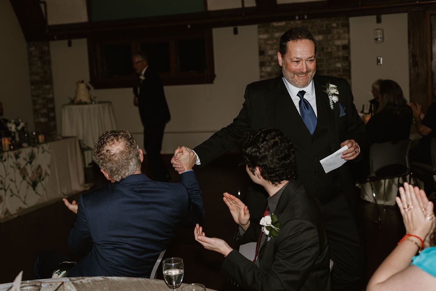 Guests join in celebration with energetic dancing and cheering at an indoor wedding reception.