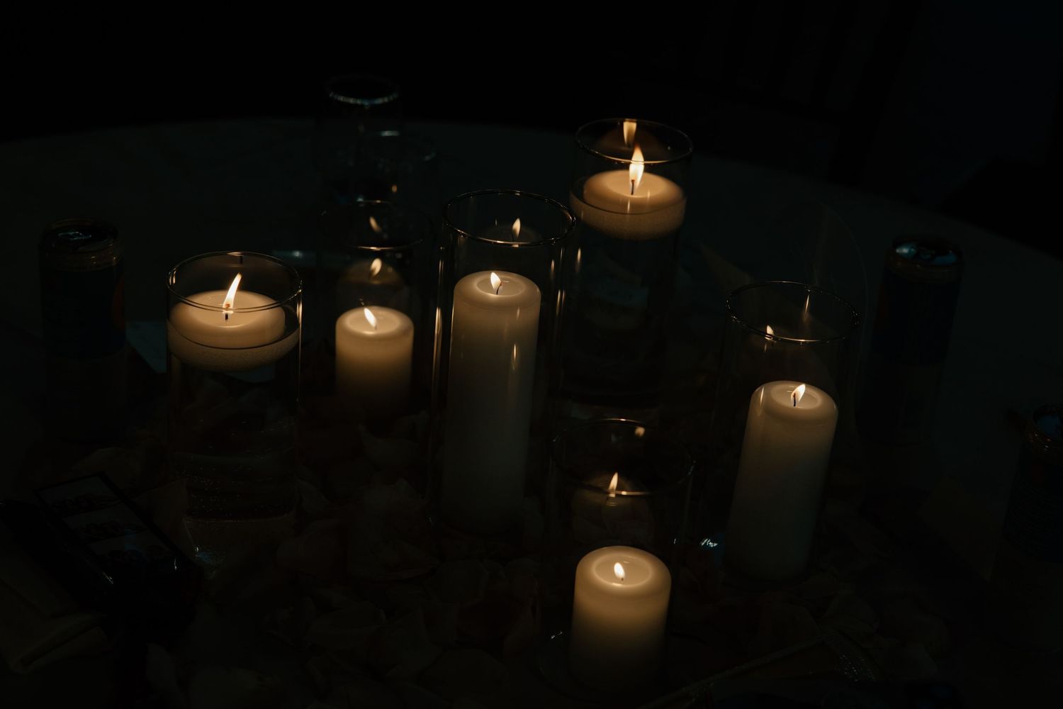 Several white candles glowing in the darkness create a peaceful and atmospheric ambiance.