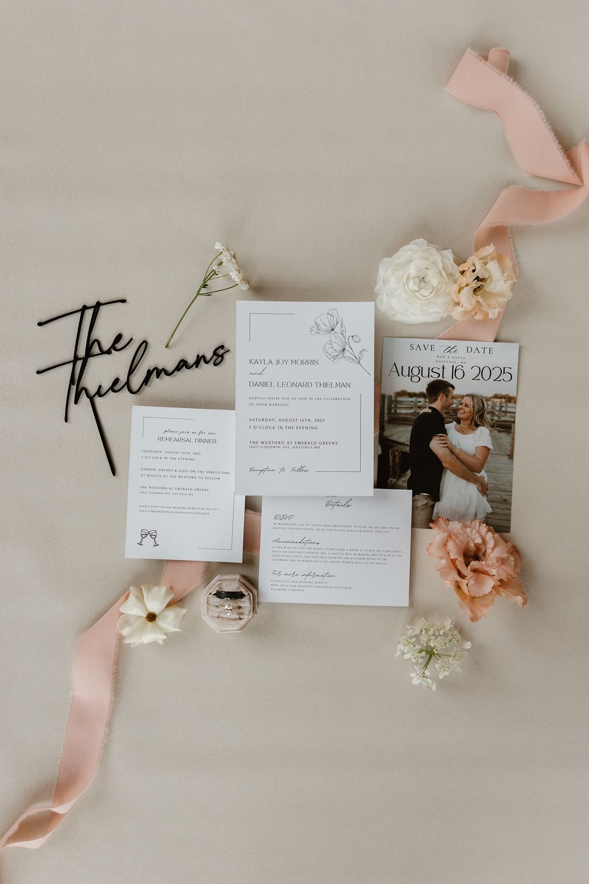Elegant wedding invitation suite with save the date card, floral accents, pink ribbon, and couple photo on beige background.