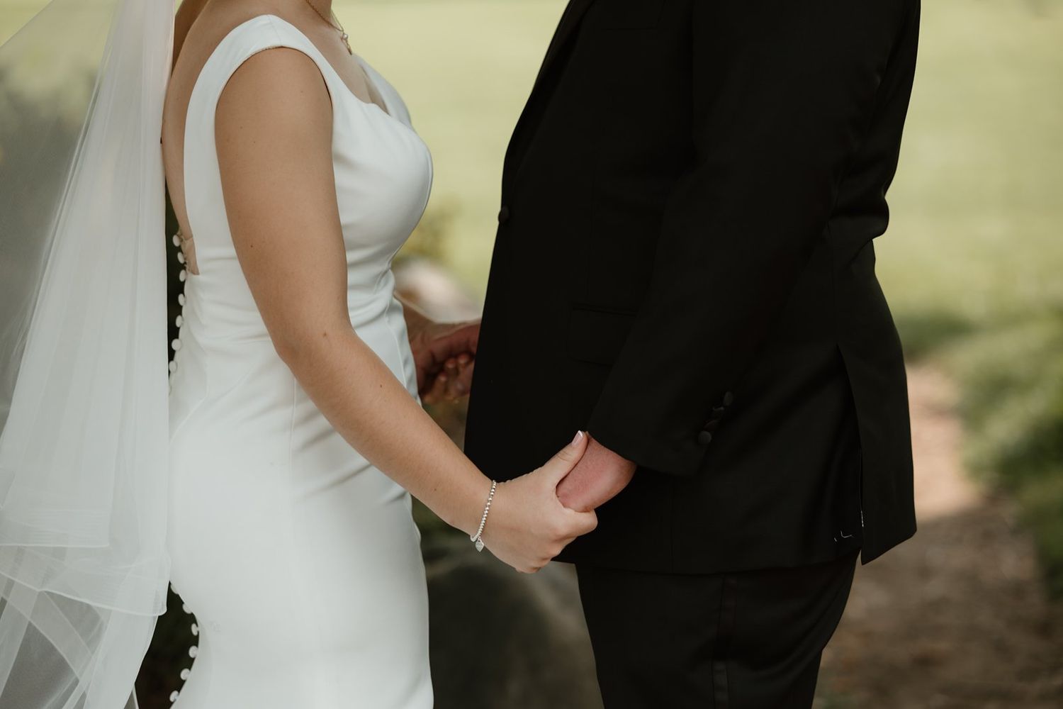 A couple in wedding attire share an intimate moment during their outdoor ceremony.