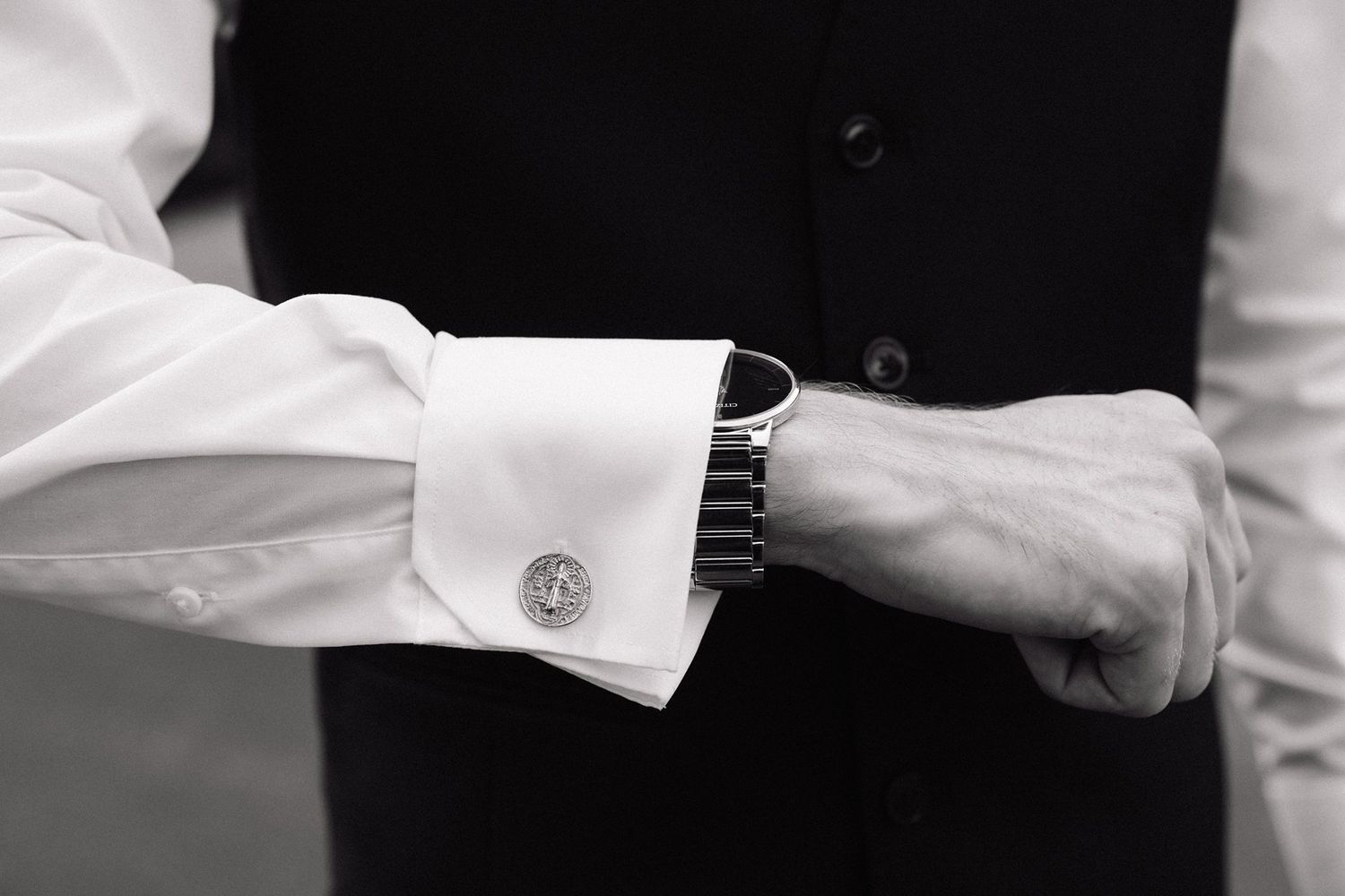 Close-up black and white photo of a crisp white dress shirt cuff with elegant cufflink detail.