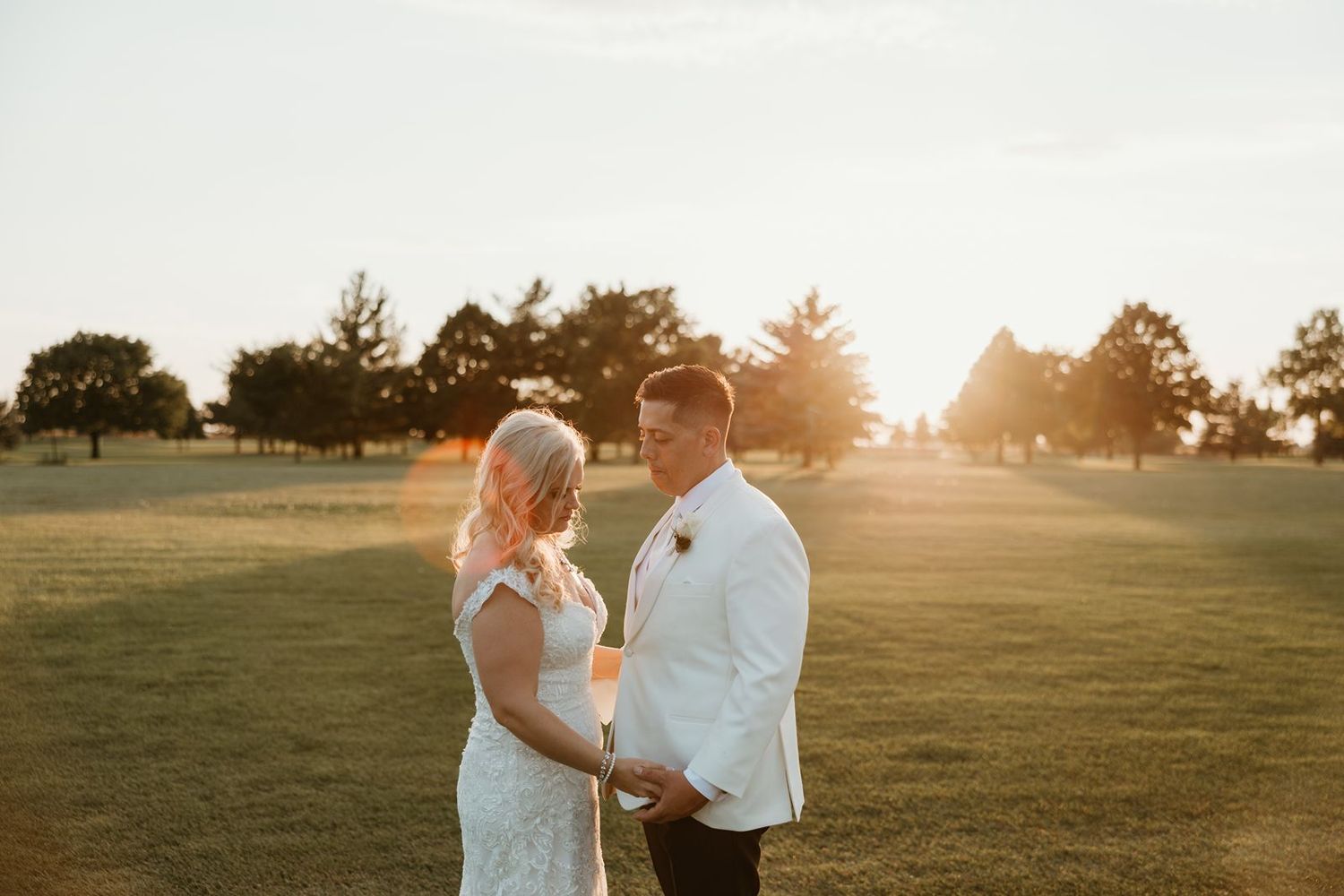 A sunset wedding portrait on a golf course with warm golden light.